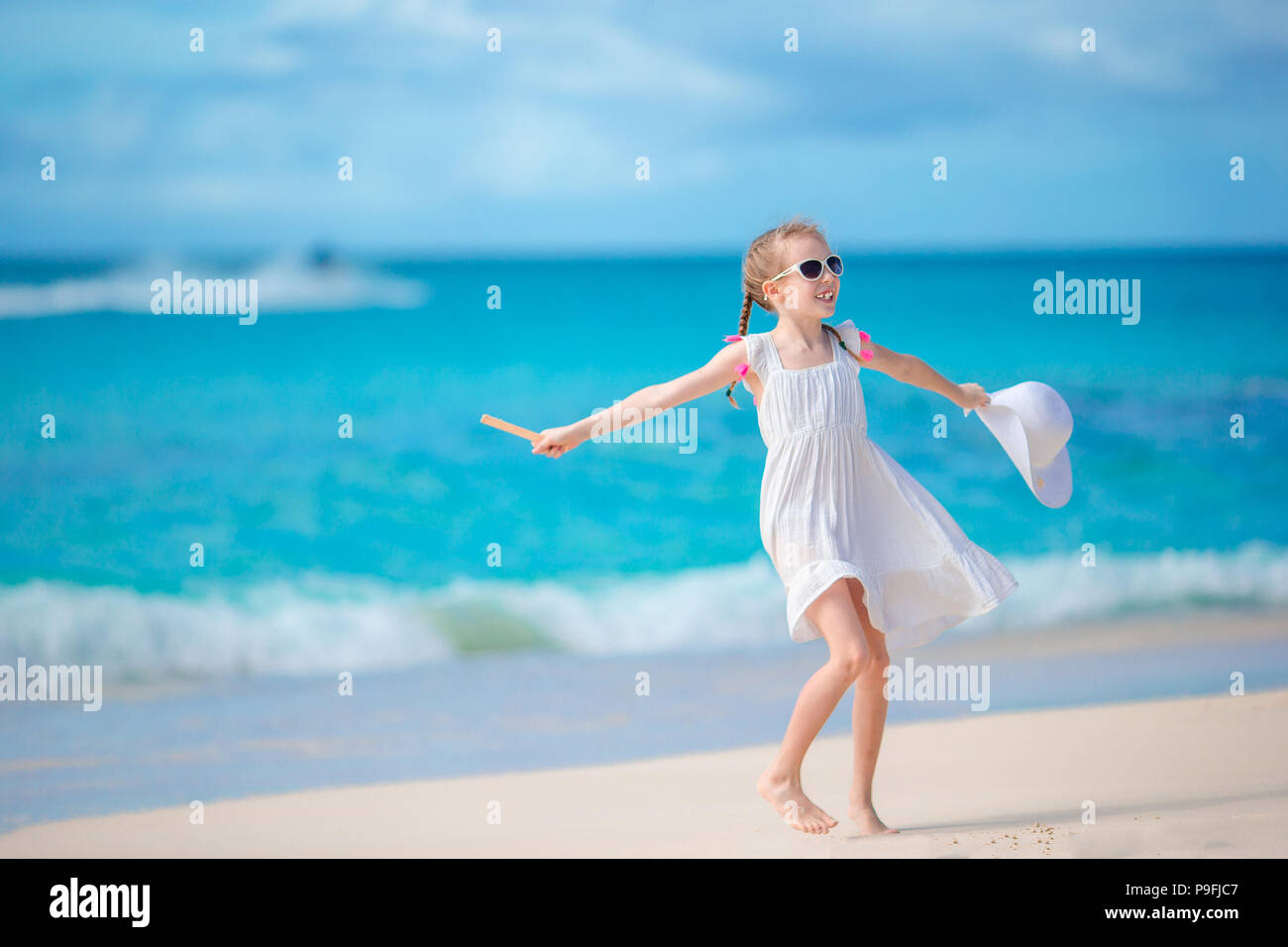 Beautiful little girl in dress at beach having fun Stock Photo Alamy