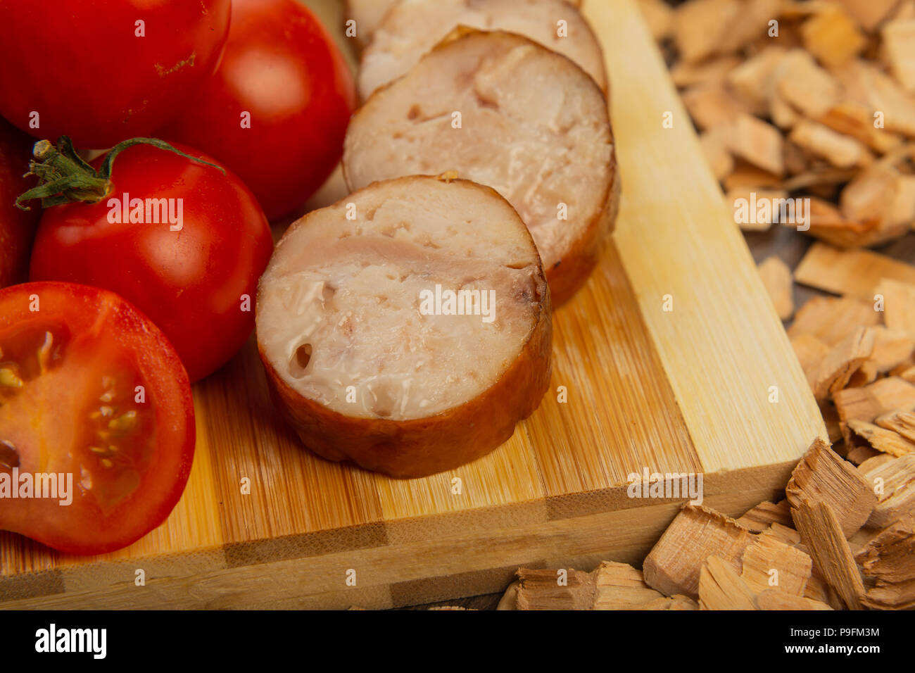 Homemade sausage on a wooden background with seasonings and sauce. Stock Photo