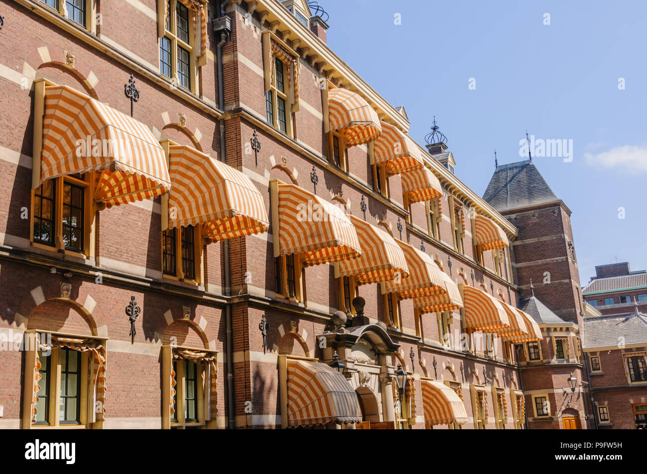 Striped fabric awnings provide shade over the windows of a building inside the Binnenhof, The Hague, Netherlands Stock Photo