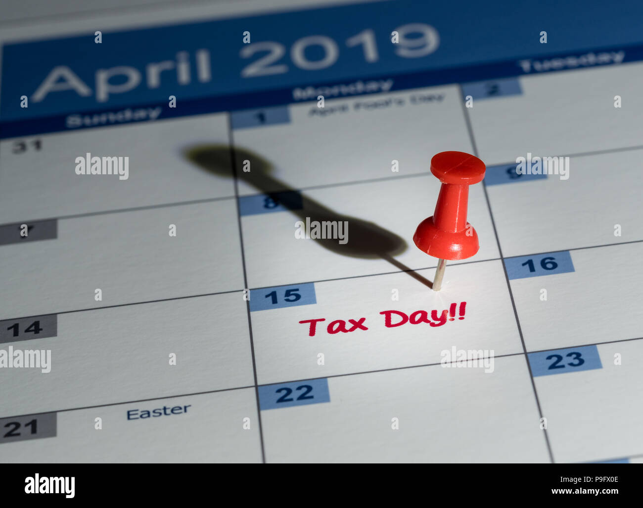 Red pushpin in calendar on April 15th for tax day Stock Photo