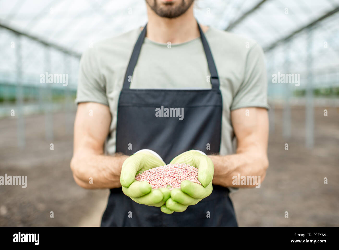 Farmer holding mineral fertilizers Stock Photo