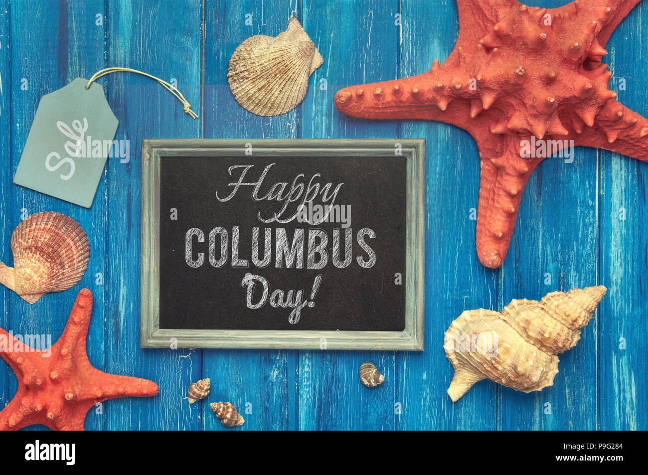Blackboard with 'Summer time' chalk text, with sea shells, rope and star fish on blue  wooden background, text 'Happy Columbus day' Stock Photo