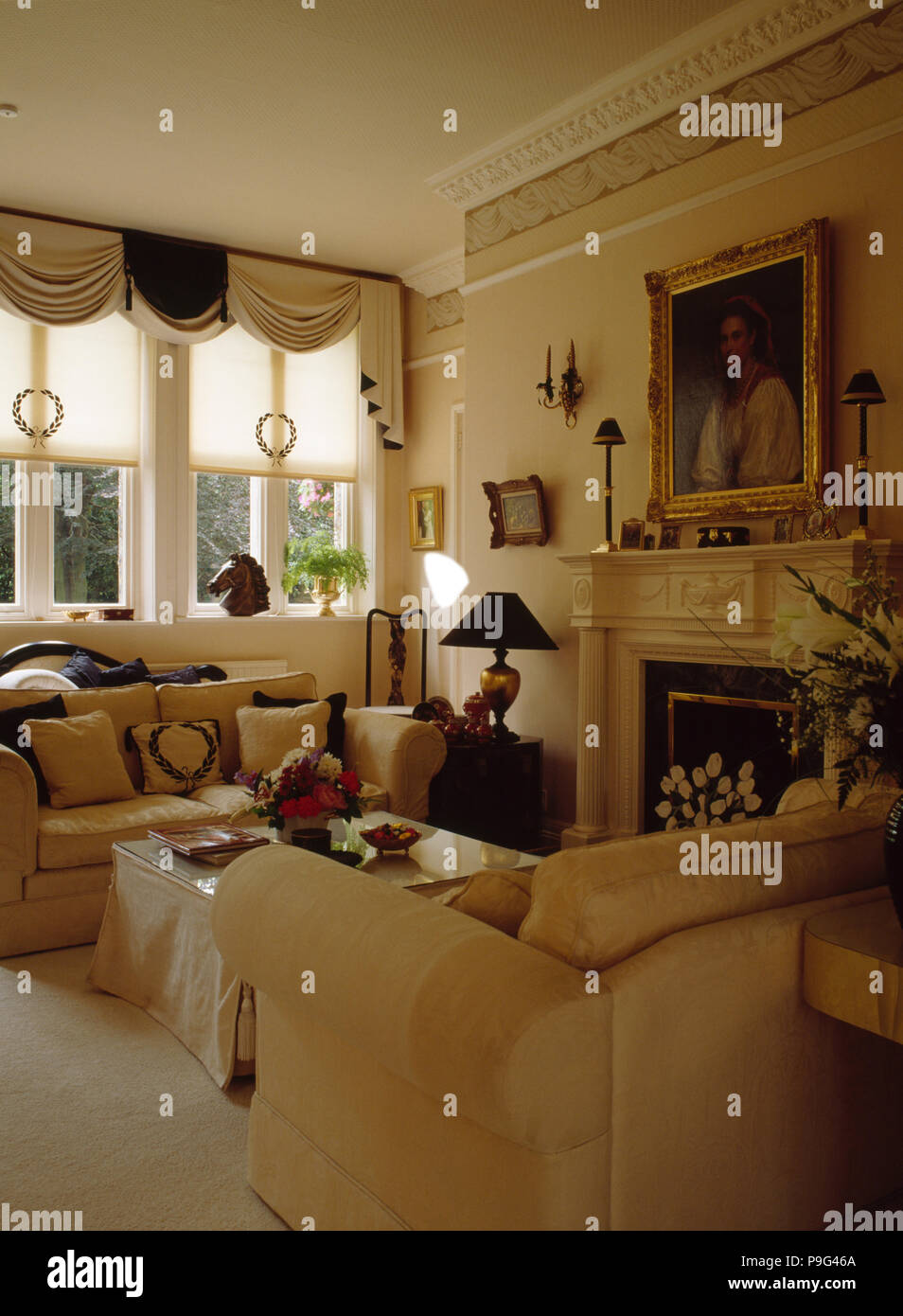 Cream blind and draped curtains in neutral living room with picture