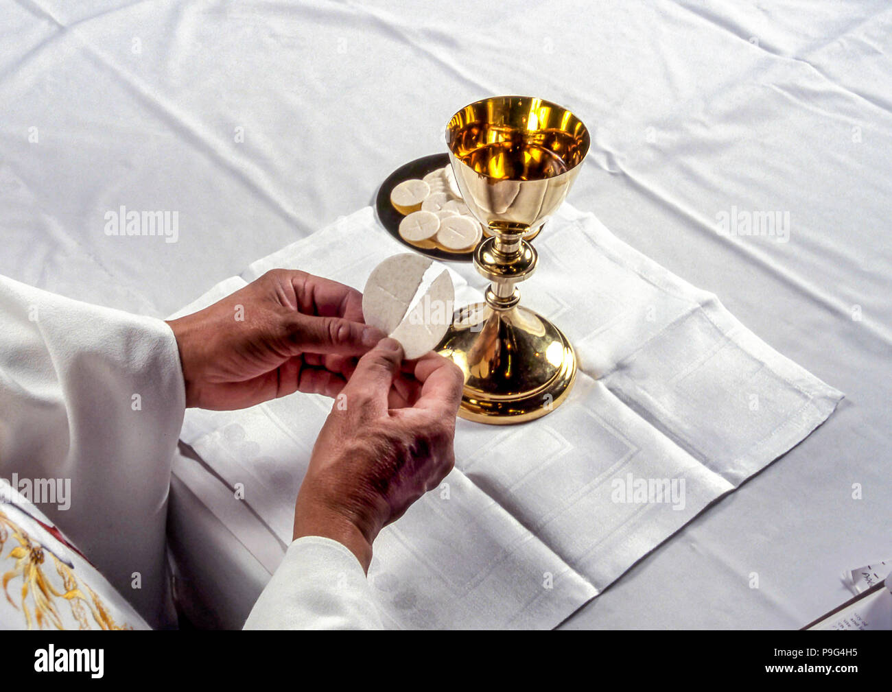 priest breaking host wafer communion  MR  © Myrleen Pearson.......Ferguson Cate Stock Photo