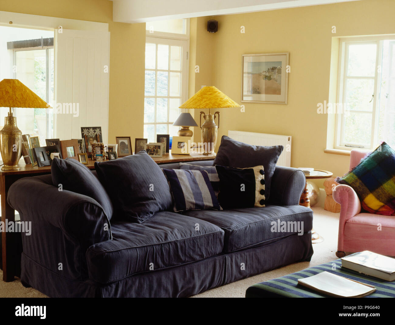 Yellow Lamps On Table Behind Blue Sofa In Country Living Room