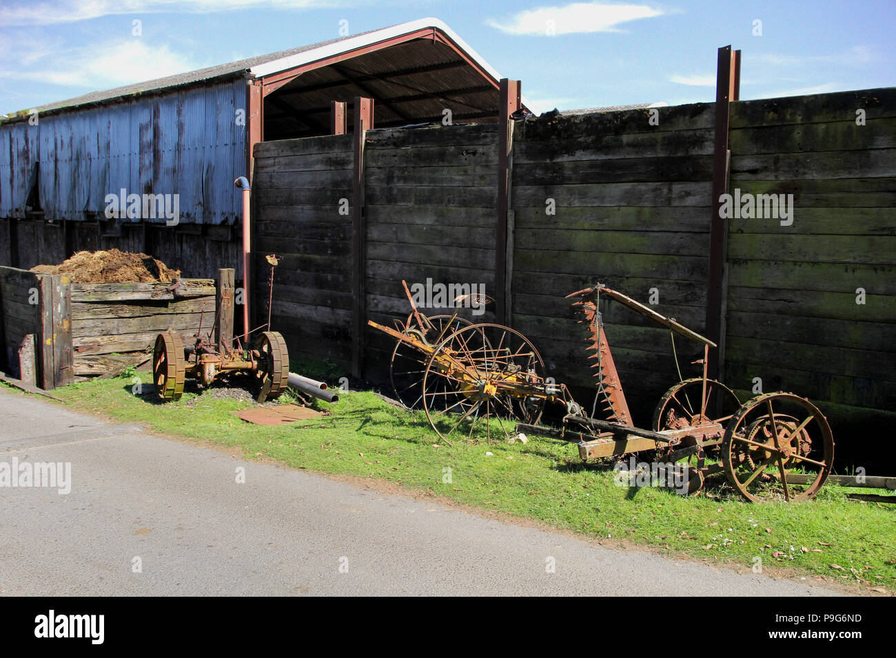 Vintage rusty old farm equipment lying unused on a grass verge in 
