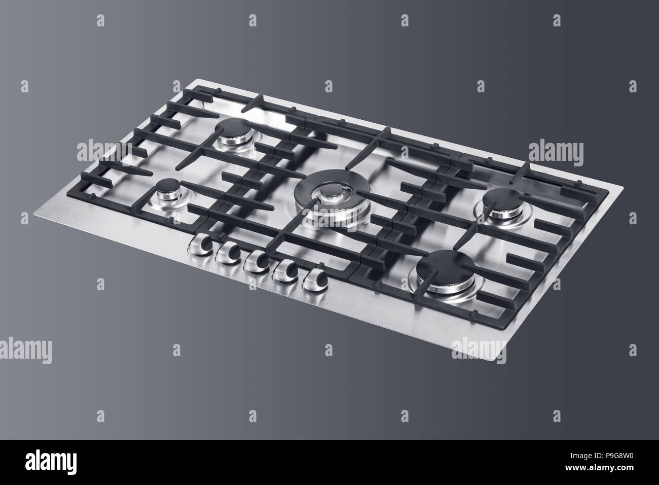 Kitchen tabletop gas hob in front of dark background, selection path