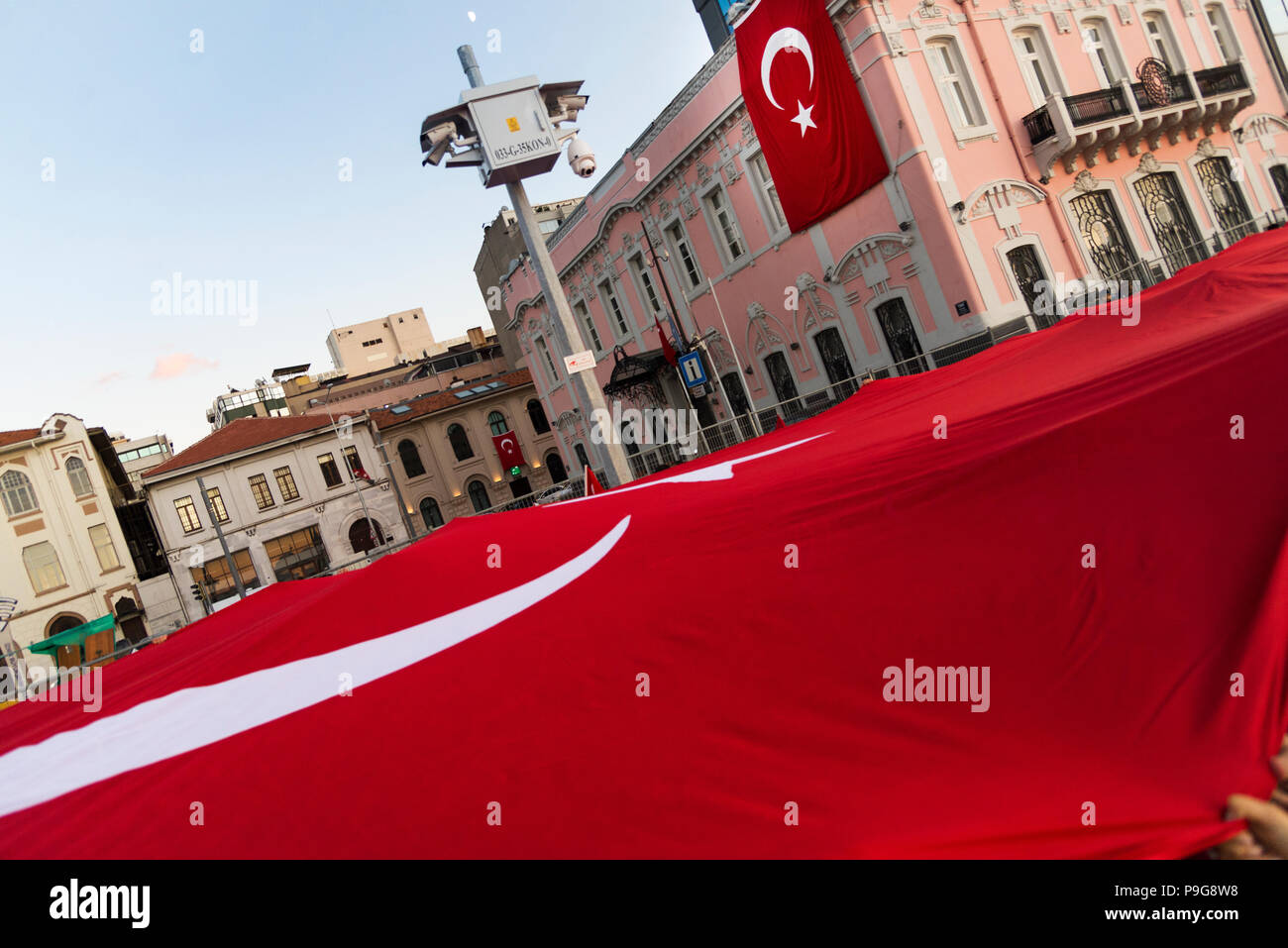 Turkish Flag on a pink building and a huge Turkish flag people carrying but we do not see any people on the image at Republic day of Turkey 29 October Stock Photo