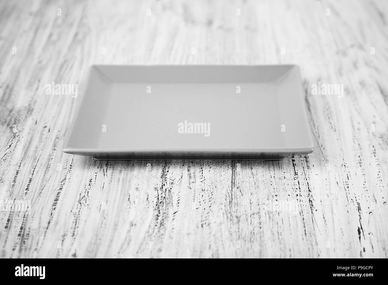 empty square plate on a wooden background Stock Photo