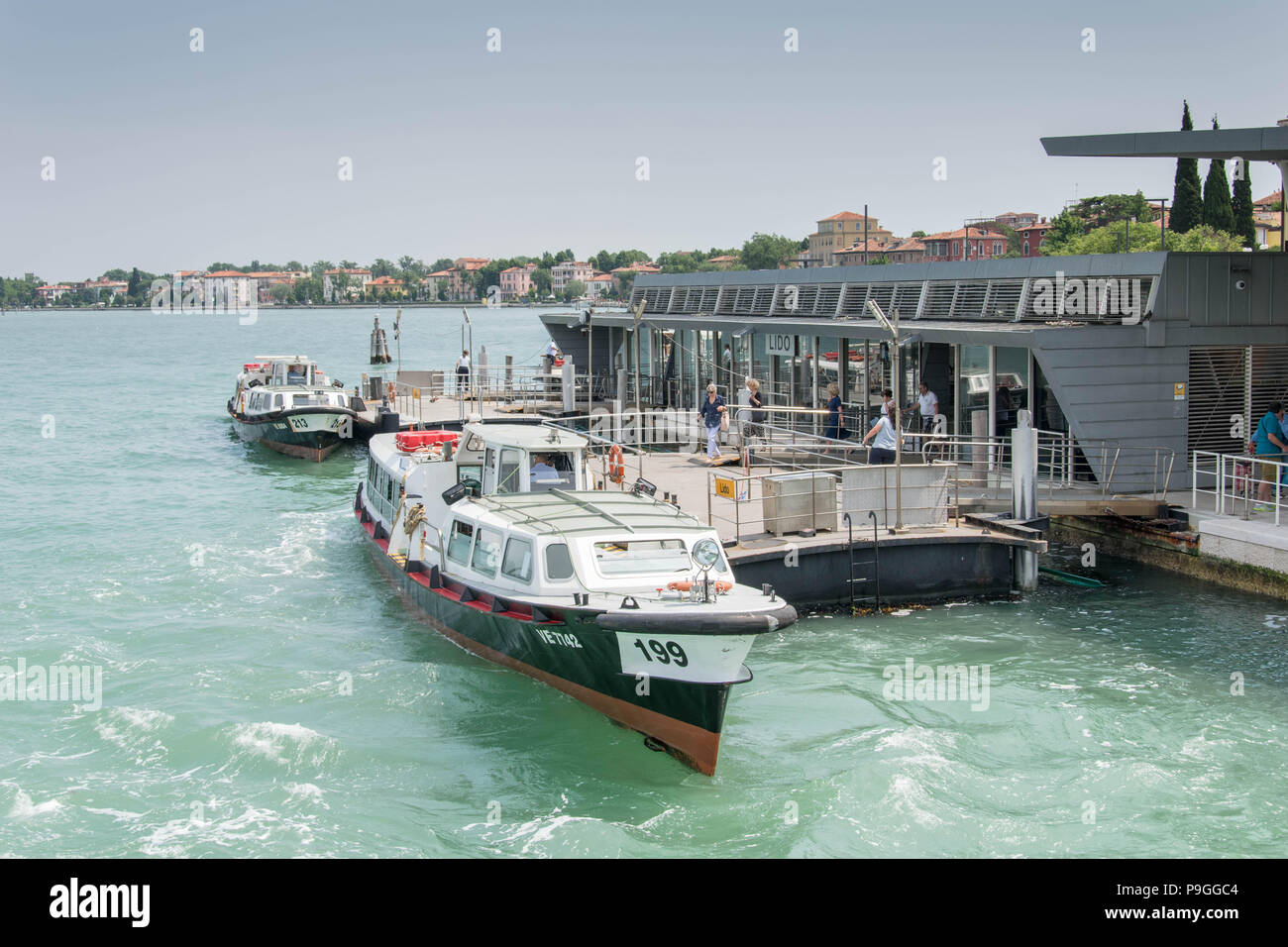 Europe, Italy, Veneto,Venice. Water tram (vaporetto) station at Lido di Venezia. Two water trams moored at the wharf. Stock Photo