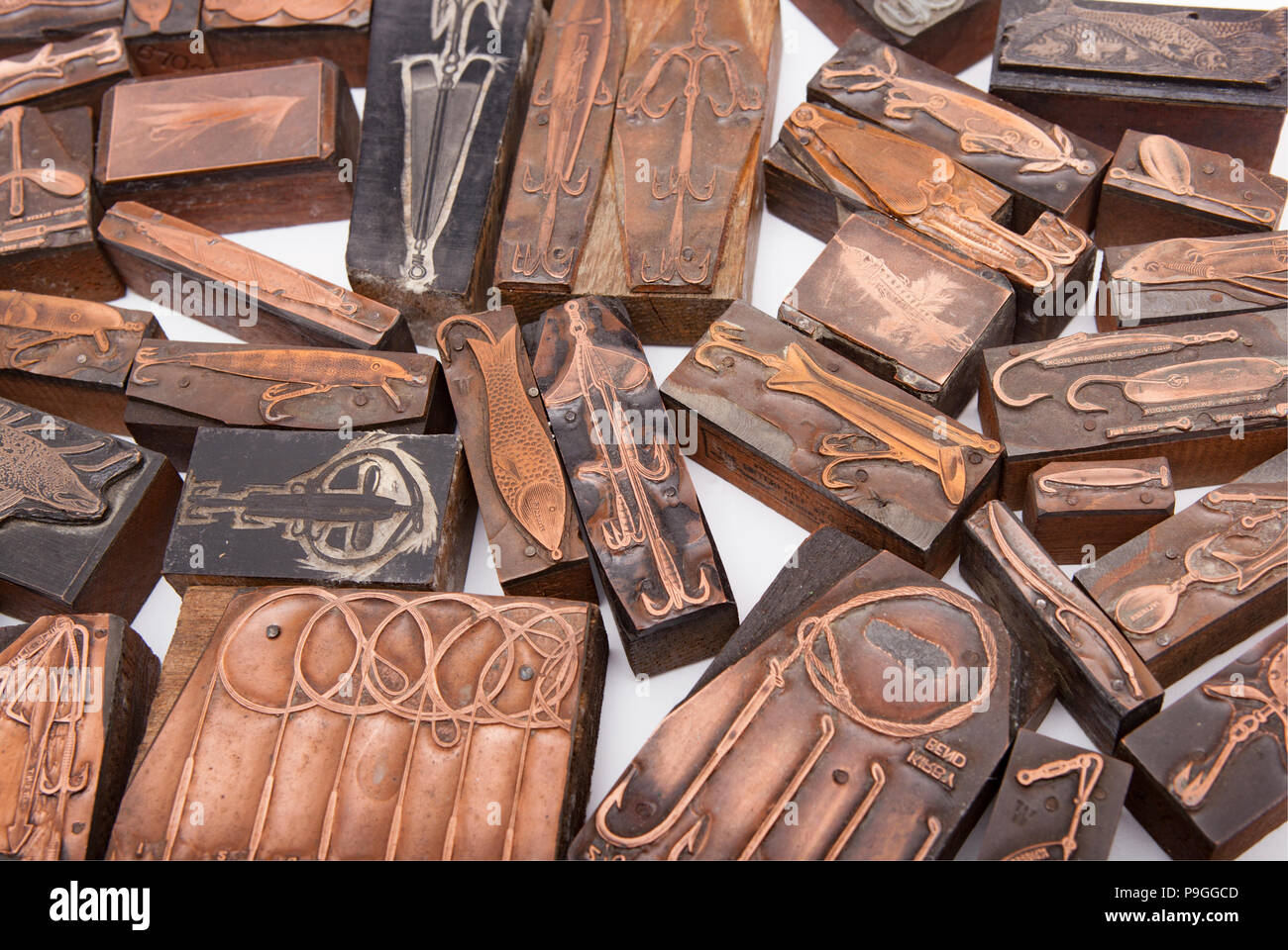 A selection of old metal and wood-backed printing blocks featuring fishing tackle and lures. From a collection of fishing tackle. Dorset England UK GB Stock Photo