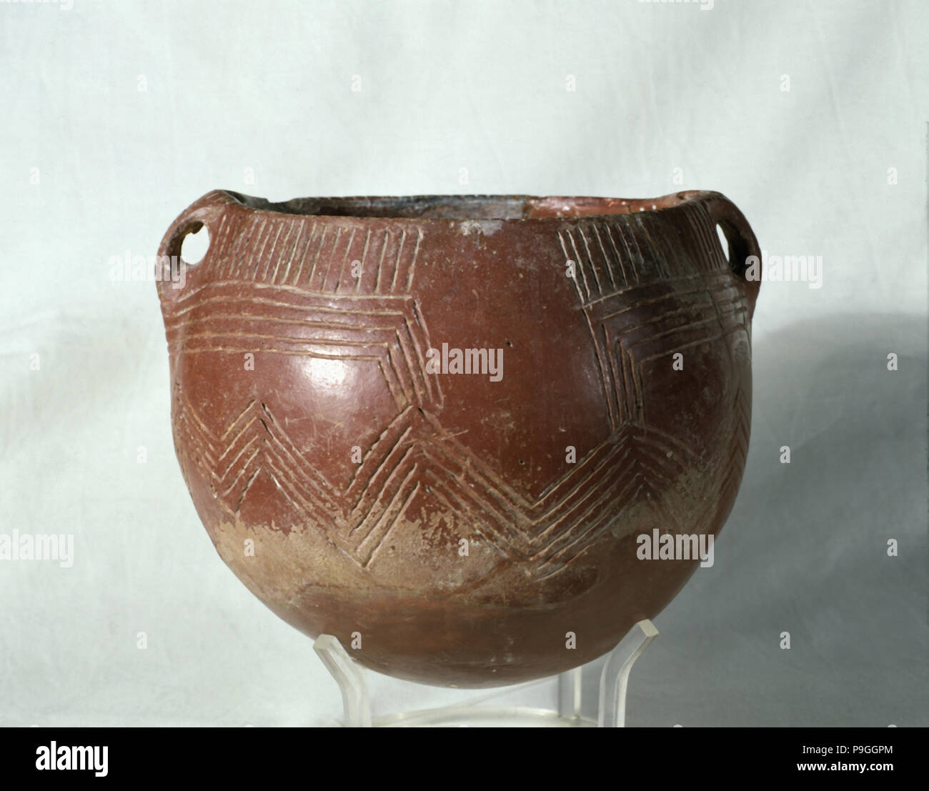 Red ochre glass (painted with a red slip of iron oxide), with incised parallel lines that form ge… Stock Photo