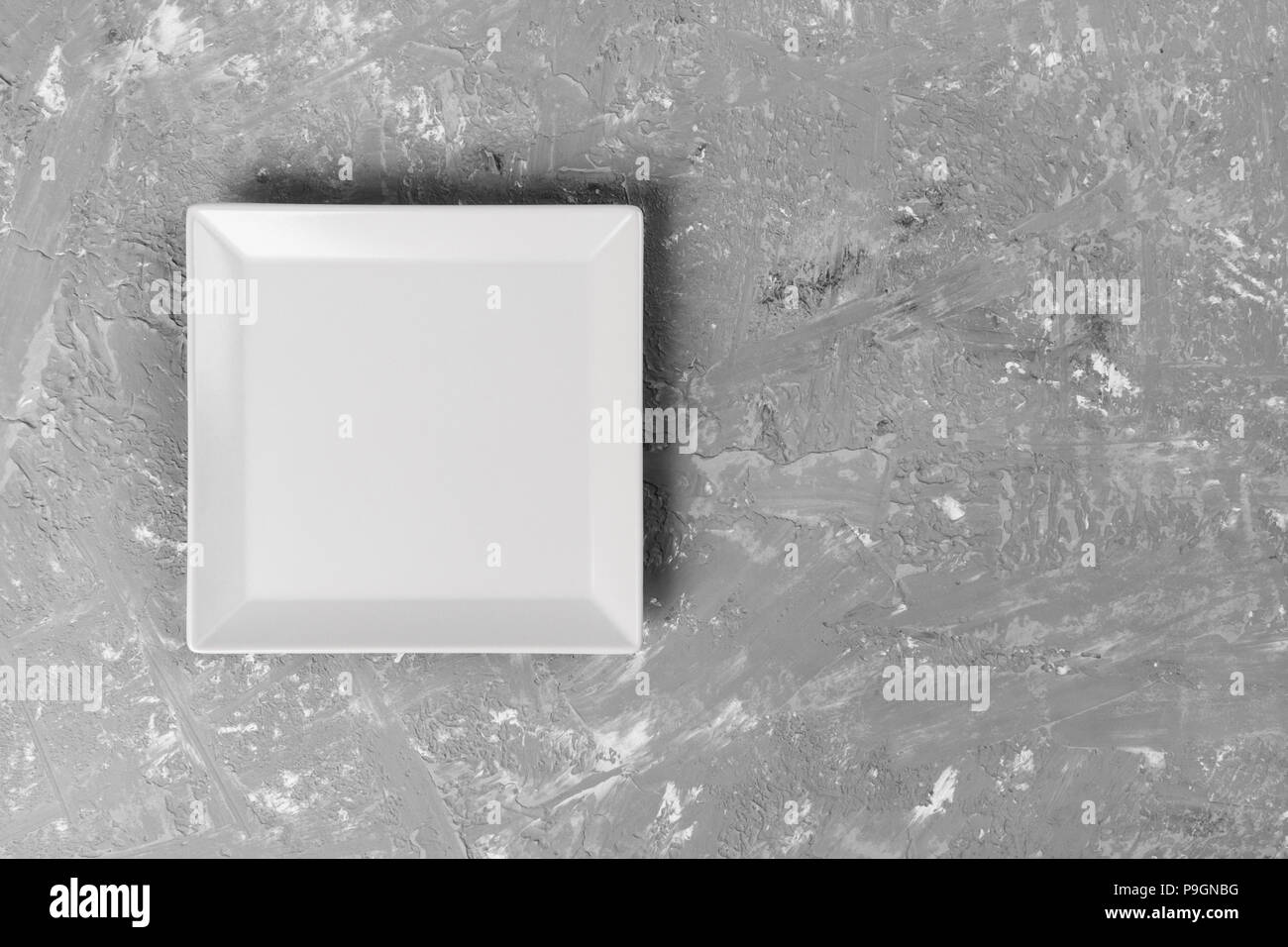 empty square plate on textured dark background. Stock Photo