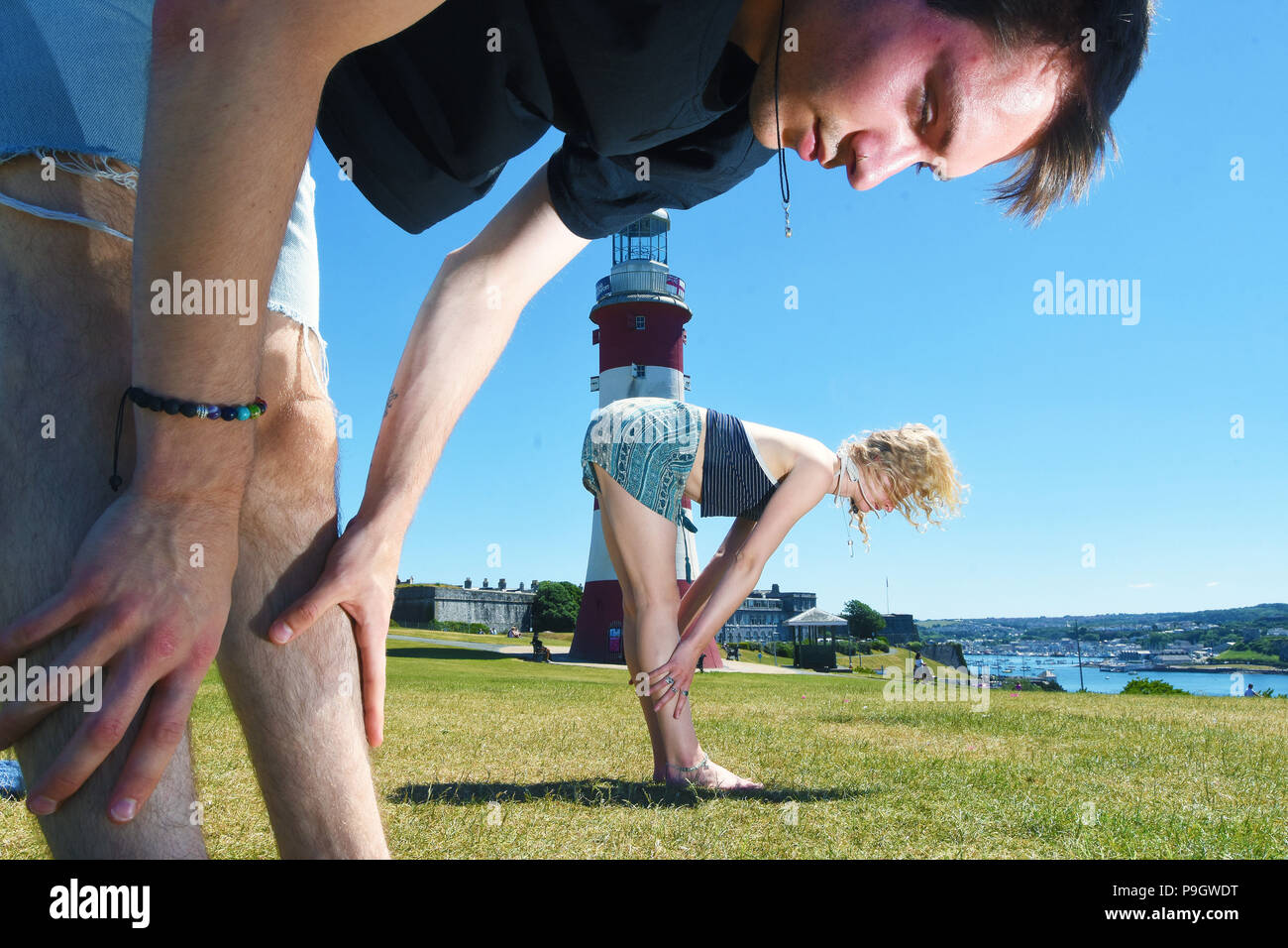 People doing Yoga in the sunshine on Plymouth Hoe Waterfront, Devon. Stock Photo