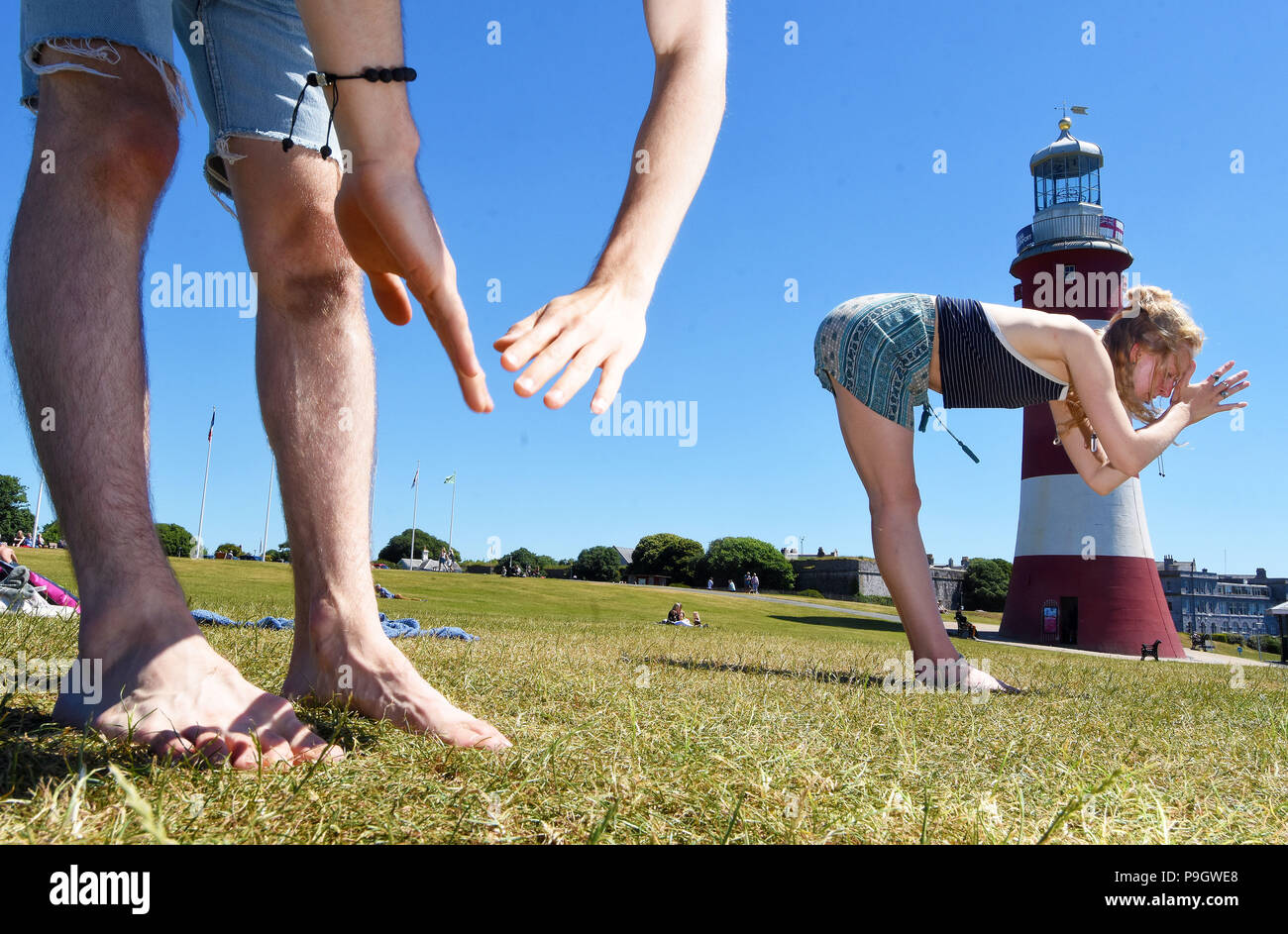 People doing Yoga in the sunshine on Plymouth Hoe Waterfront, Devon. Stock Photo