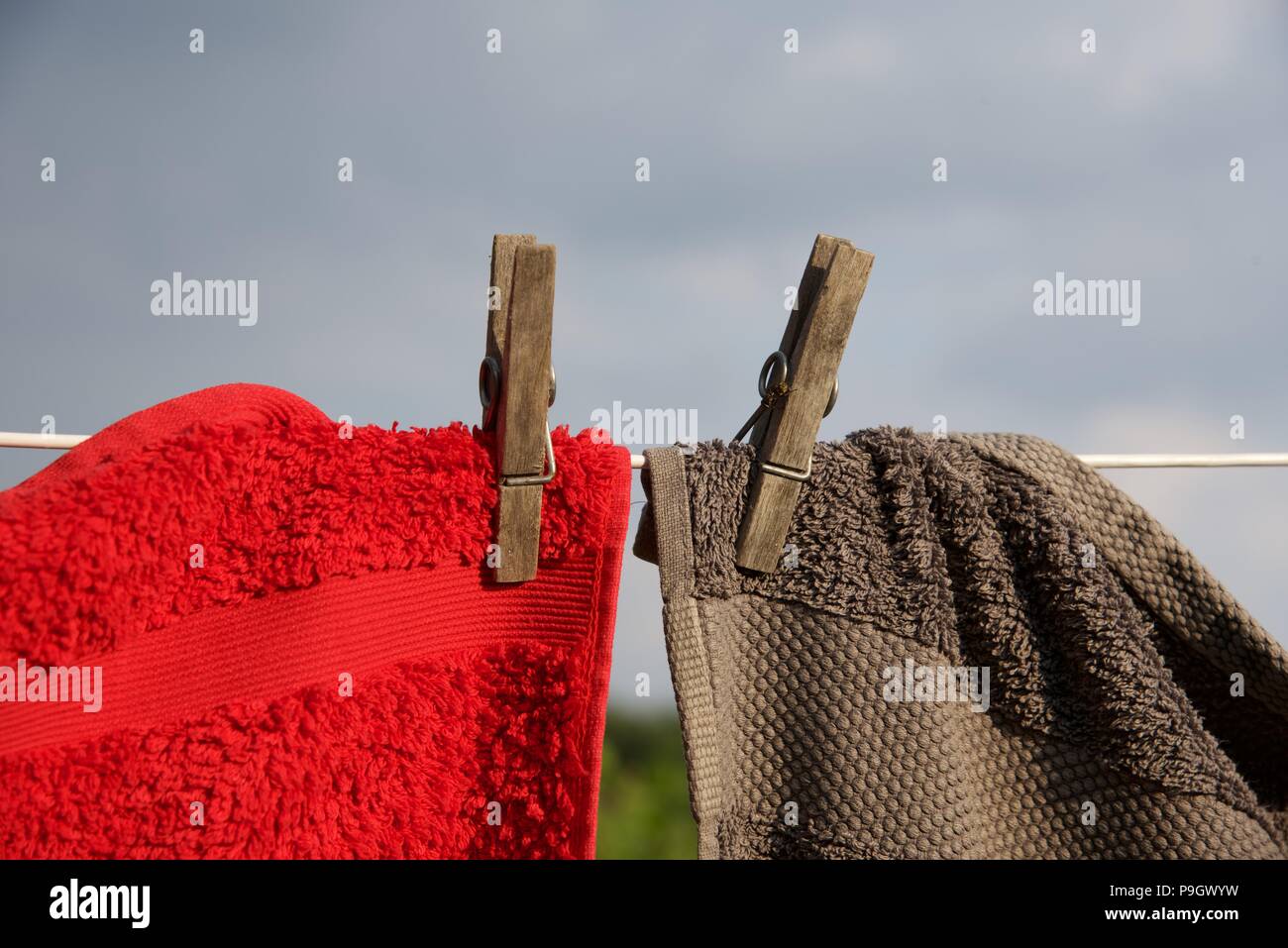 Washing line red and grey towels hung with sprung wooden pegs on a