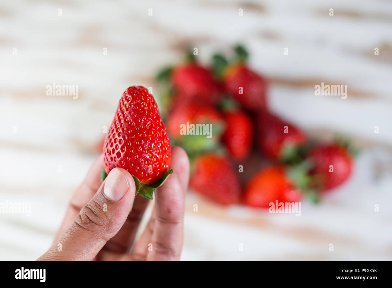 Strawberry in hand full, healthy food eating Stock Photo - Alamy
