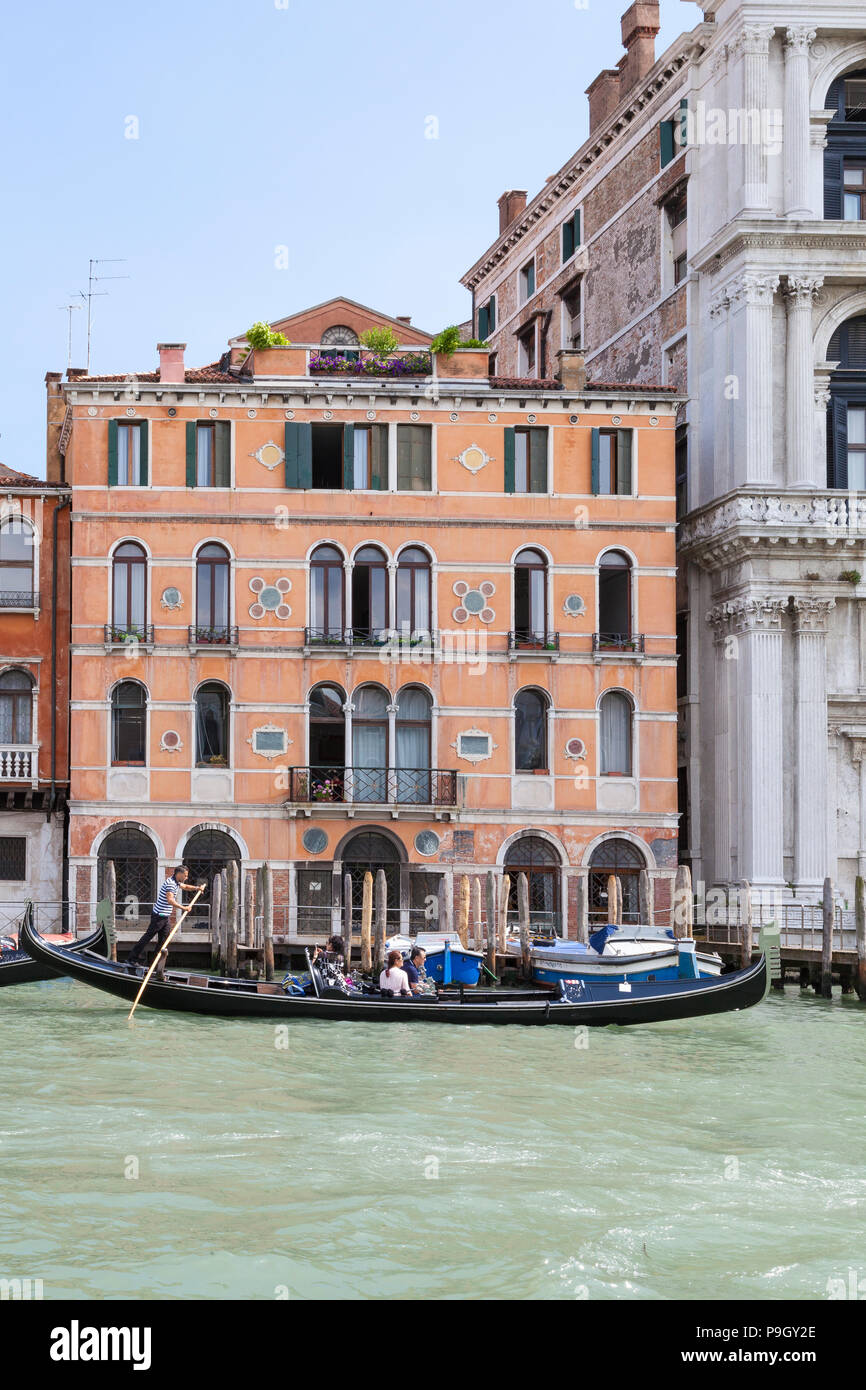 Palazzo (Corner) Valmarana, Grand canal, San Marco, Venice, Veneto, Italy with a gondola with tourists passing in the foreground Stock Photo