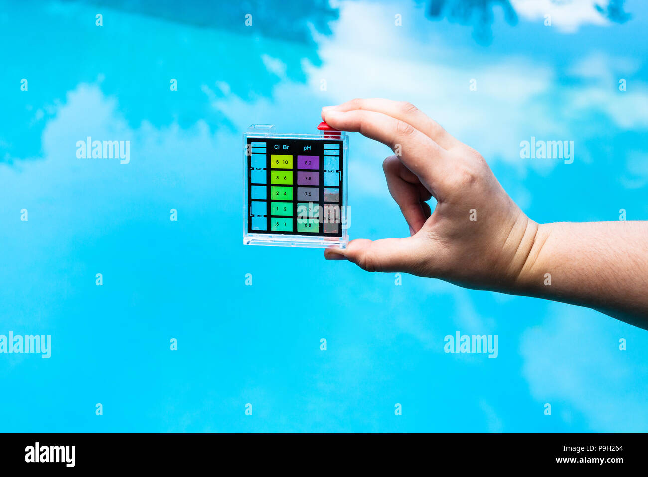 hand holds pH indicator for measure the acidity of water in a swimming