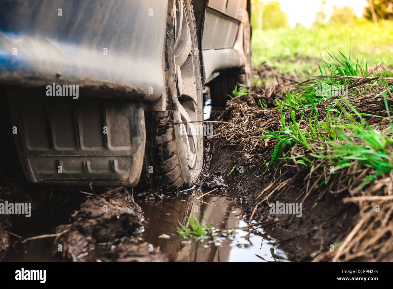 the wheel of a passenger car stuck in the mud on an offroad Stock