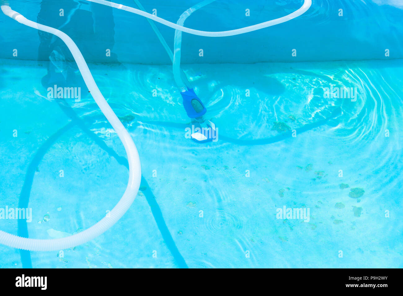 vacuuming of bottom of outdoor swimming pool in summer day Stock Photo