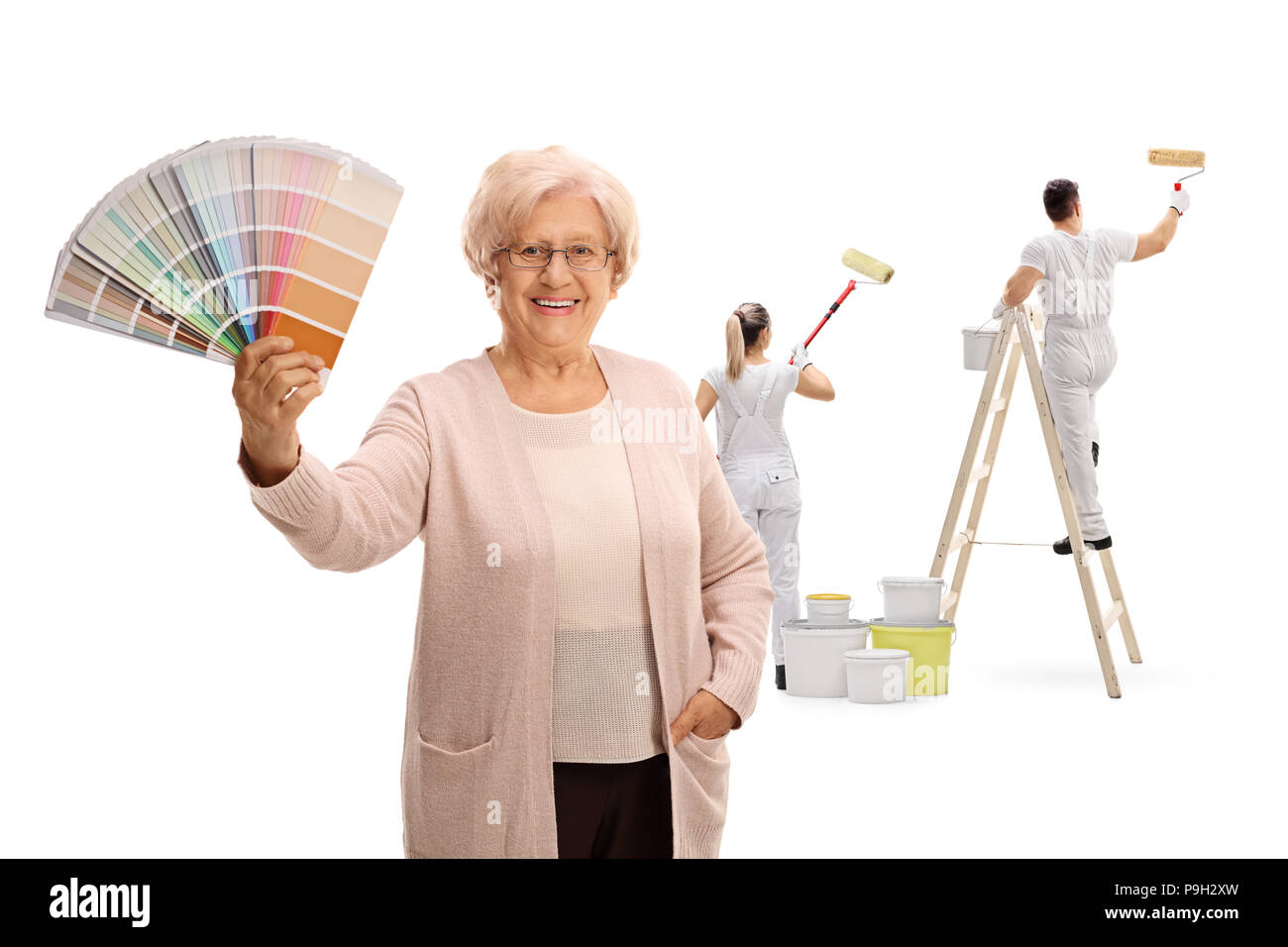 Mature woman holding a color swatch with two painters painting behind her isolated on white background Stock Photo