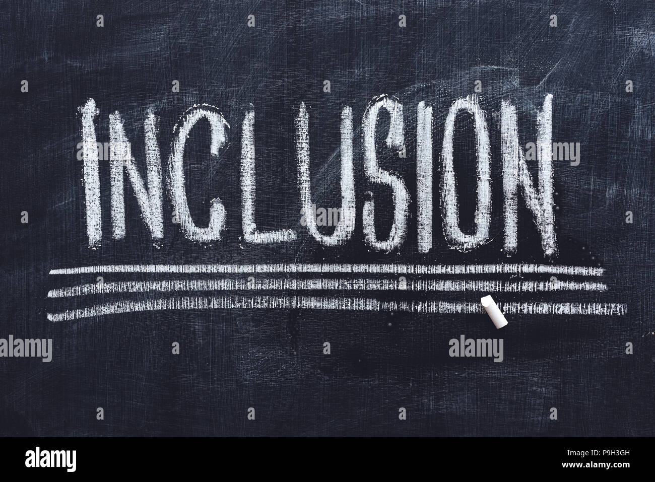 Word Inclusion on school blackboard written with chalk Stock Photo