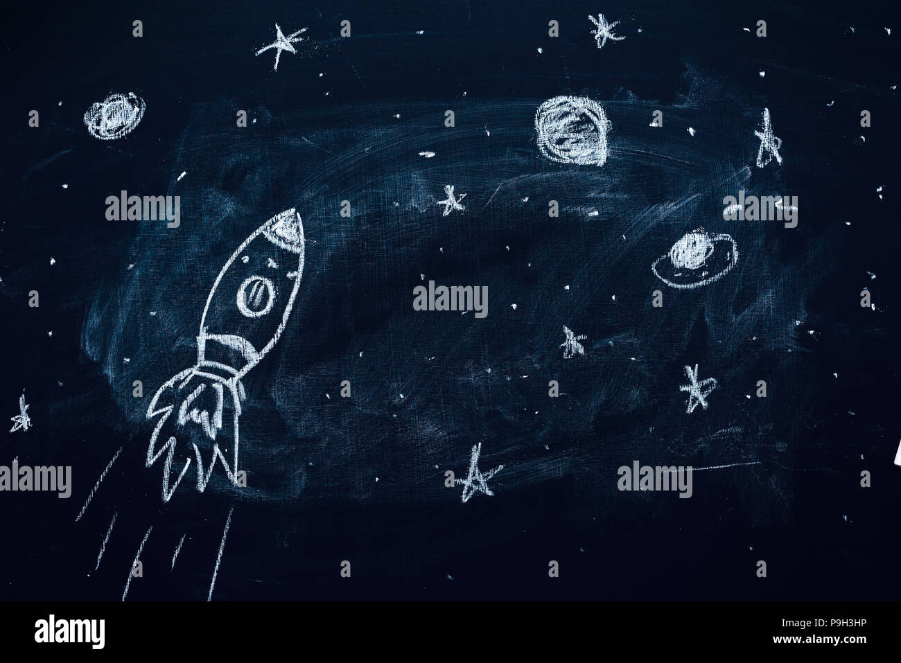 Space rocket with planets and stars doodle drawing on school chalkboard Stock Photo