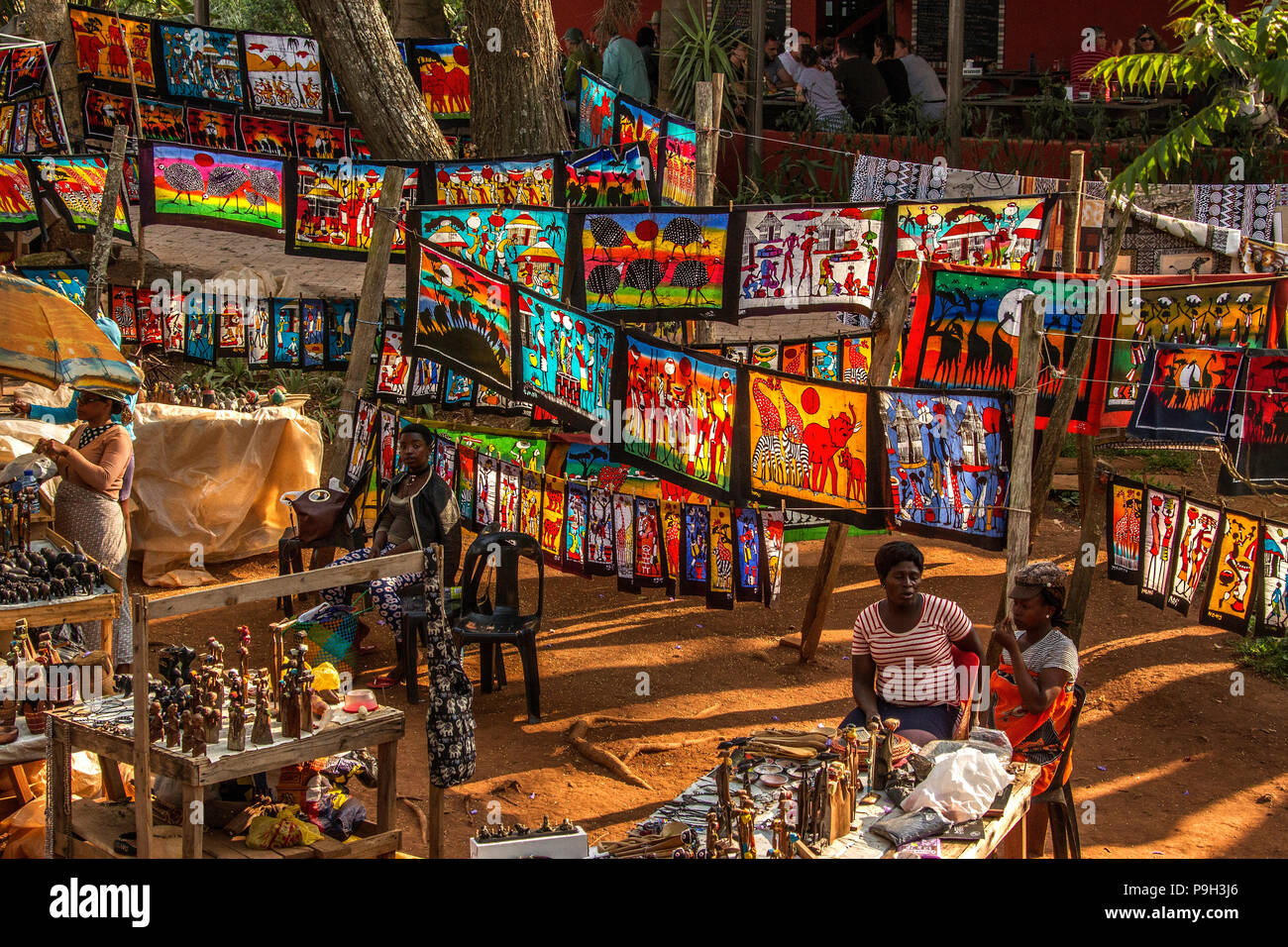 Ezulwini Craft market in Swaziland, towards the end of a busy day, showing colourful batik fabric painting and a variety of other products for sale. Stock Photo