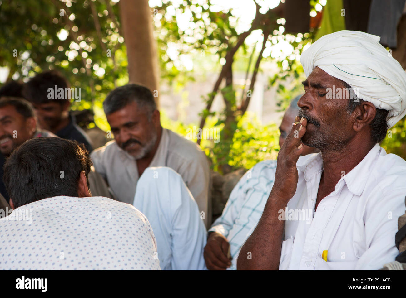 montez cigarettes friends A man smoking a cigarette with a group of friends Stock Photo