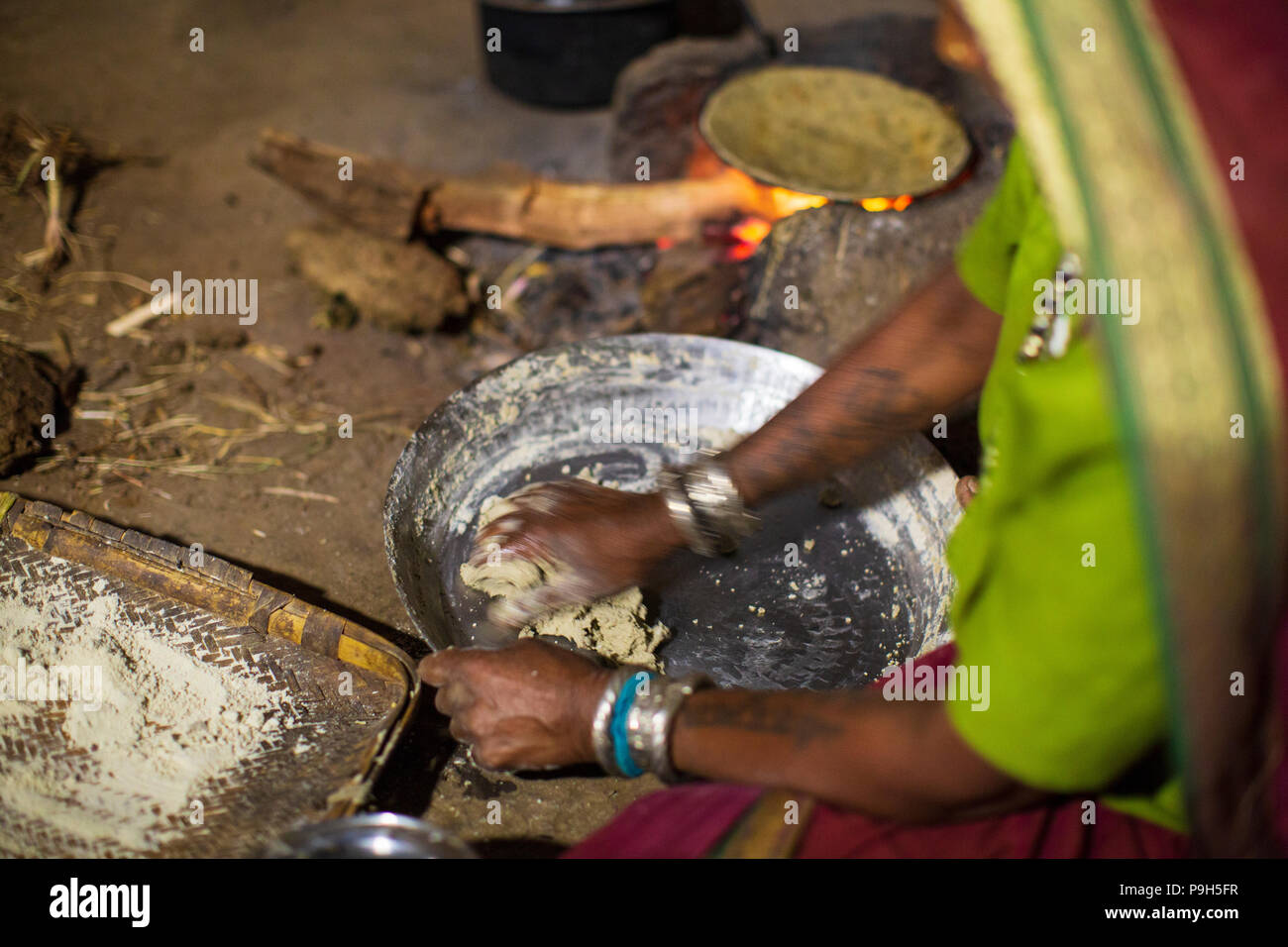 A woman making chapatis on an open fire in her kitchen, Sendhwa, India. Stock Photo