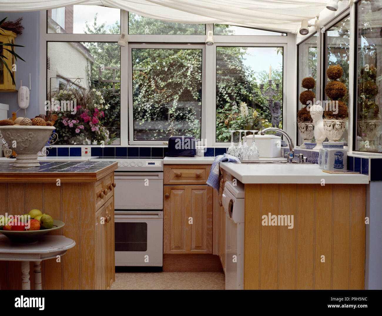 Pale Wood Fitted Units And White Cooker In A Conservatory Kitchen Stock Photo Alamy