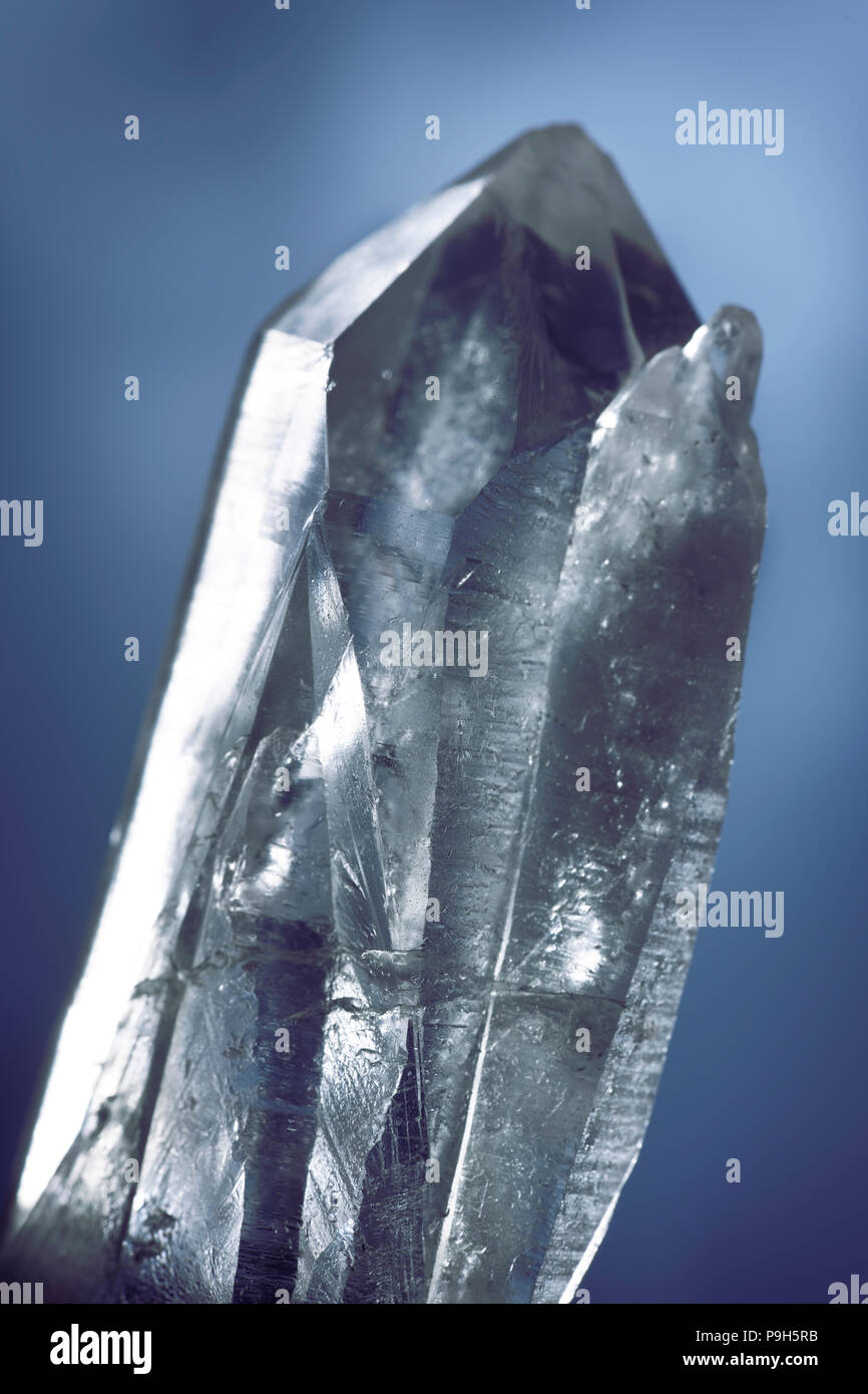 Closeup of a Lemurian Quartz healing crystal used for spiritual practices and meditation on dark blue background Stock Photo