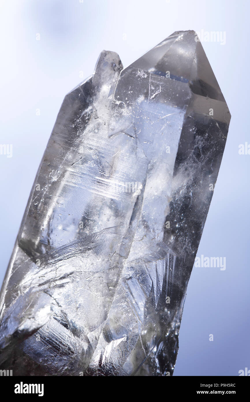 Sparkling Lemurian Quartz healing crystal used for spiritual practices and meditation on light blue background Stock Photo