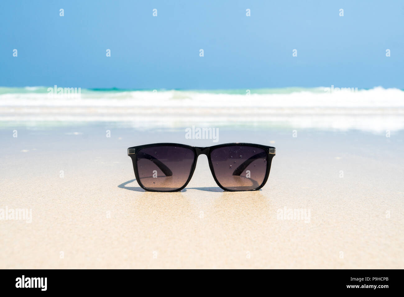 Sun glasses lie on a beach near the sea. black sunglasses on the ...