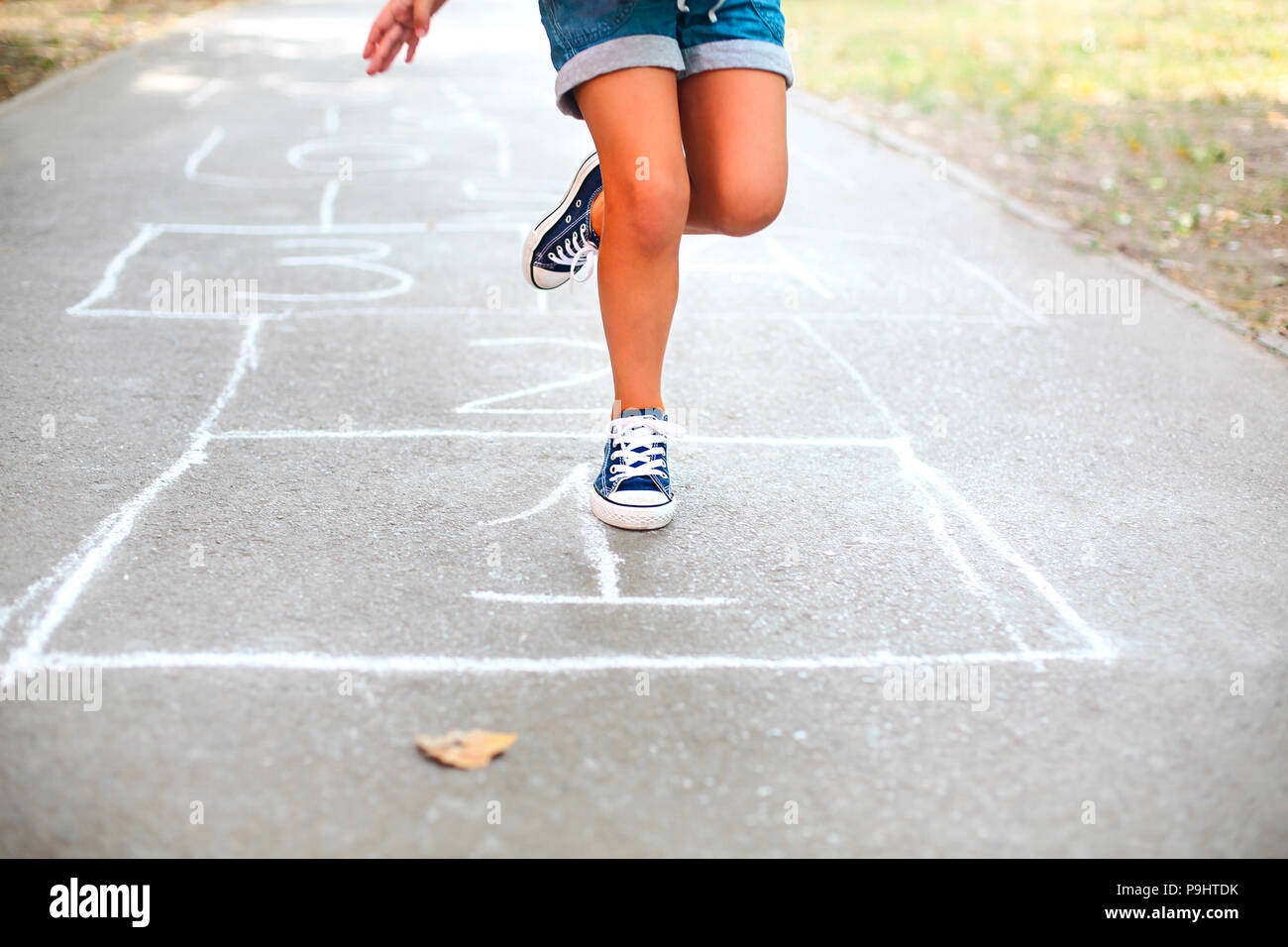 Kid playing hopscotch on playground outdoors, children outdoor activities Stock Photo