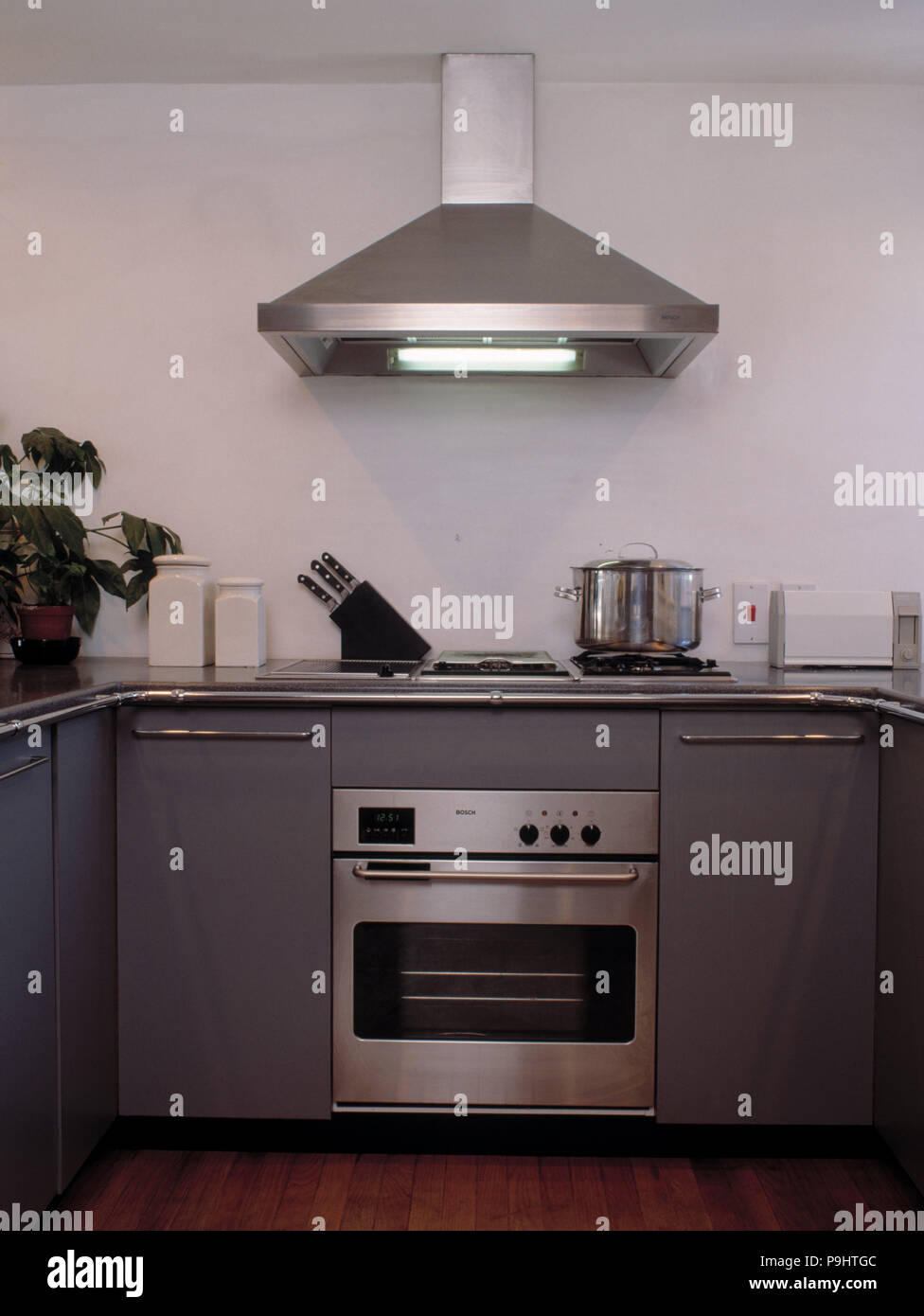 Stainless grey metal kitchen gas stove installed on a the kitchen with a  dark grey table top Stock Photo - Alamy