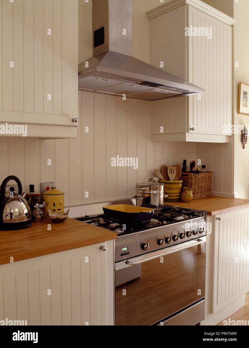 Stainless steel extractor and range oven in a white kitchen with a