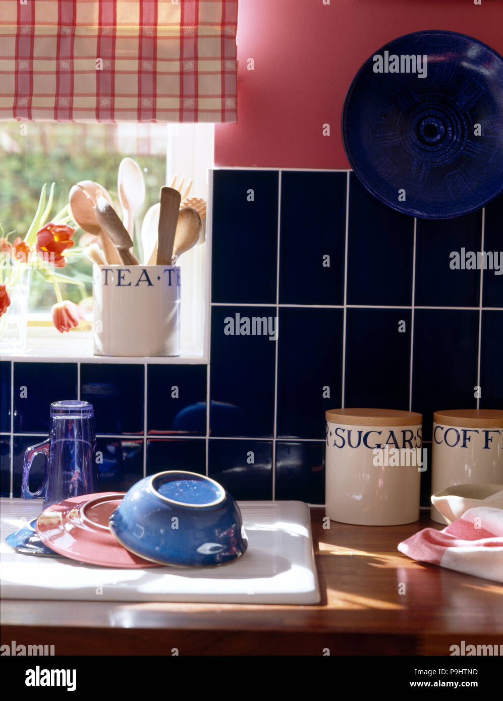 Closeup of crockery drying on draining board beside worktop with