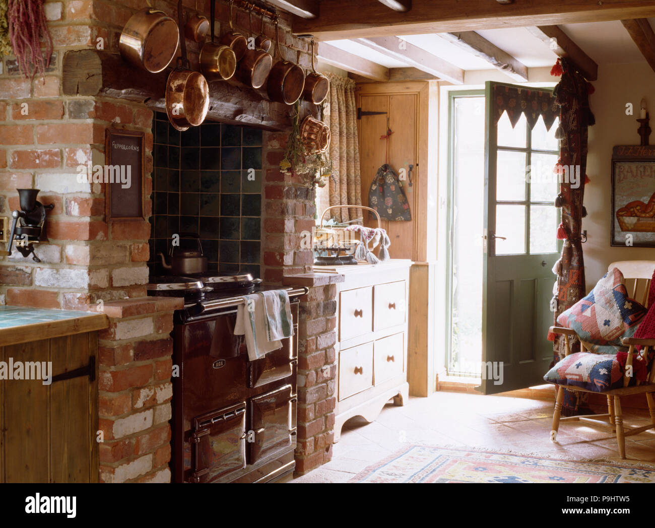Black Aga in brick fireplace in cottage kitchen Stock Photo
