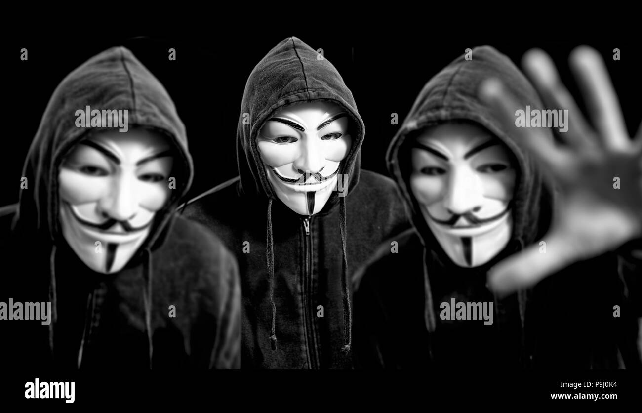 Anonymous hackers wearing  Guy Fawkes masks and a black hoodies Stock Photo