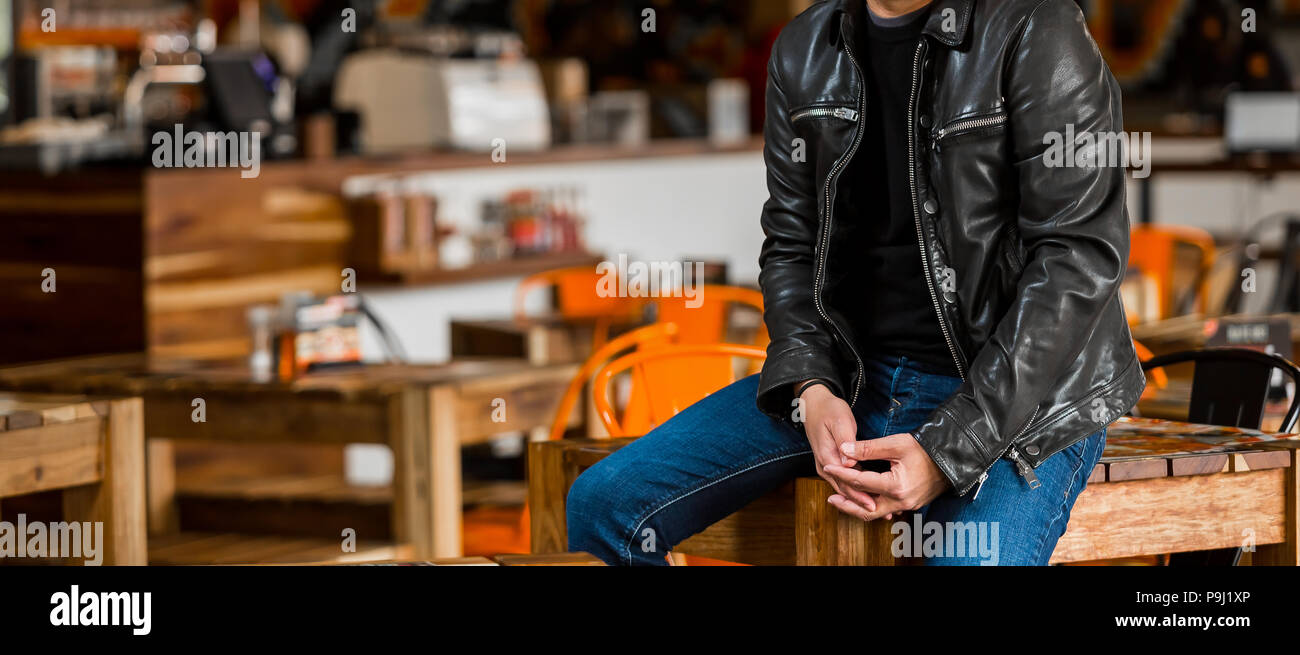 Cropped Head Caucasian Man in casual T-Shirt and leather jacket in a restaurant Stock Photo