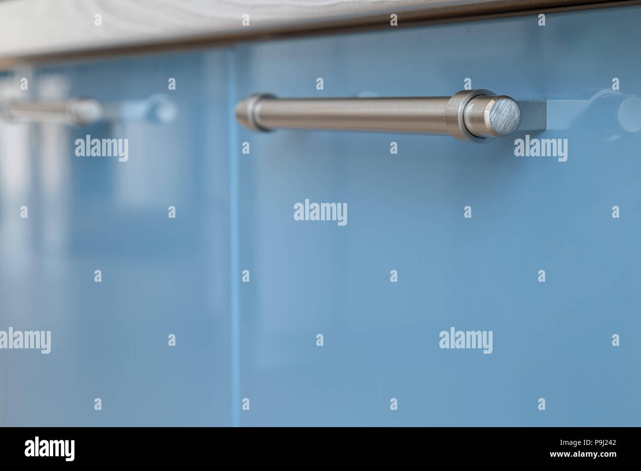 Iron handle on kitchen furniture from varnished materials. Stock Photo