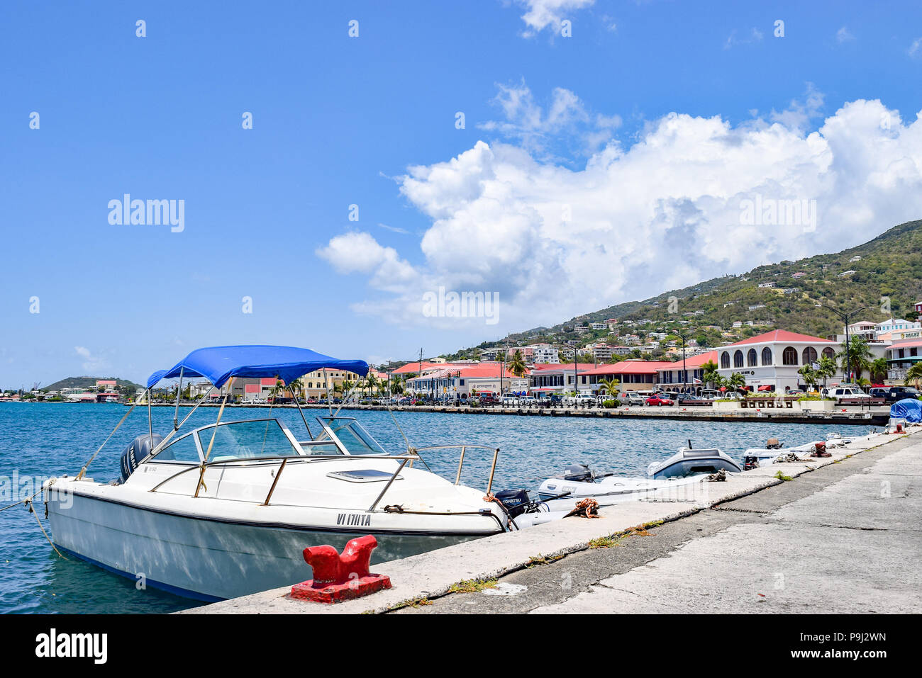 Saint Thomas, US Virgin Islands - April 01 2014: A sailboat and some speedboats docked in downtown Saint Thomas in the US Virgin Islands. Stock Photo
