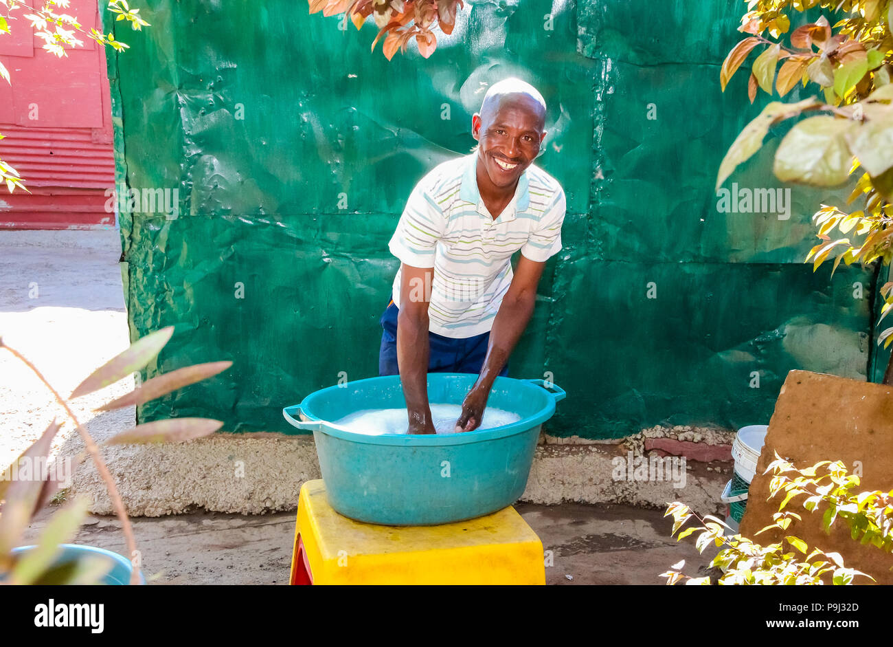 Johannesburg, South Africa, September 11, 2011, Male teacher washing