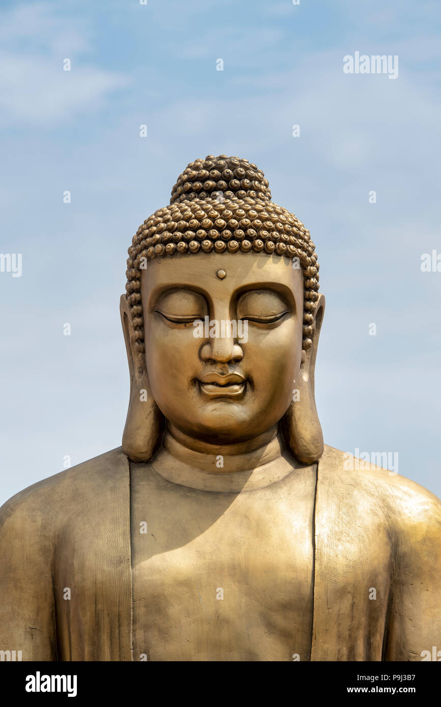 Golden Buddha Statue against a blue sky. UK Stock Photo