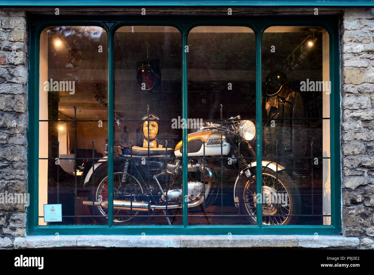 Vintage triumph motorcycle on an antiques shop window display in