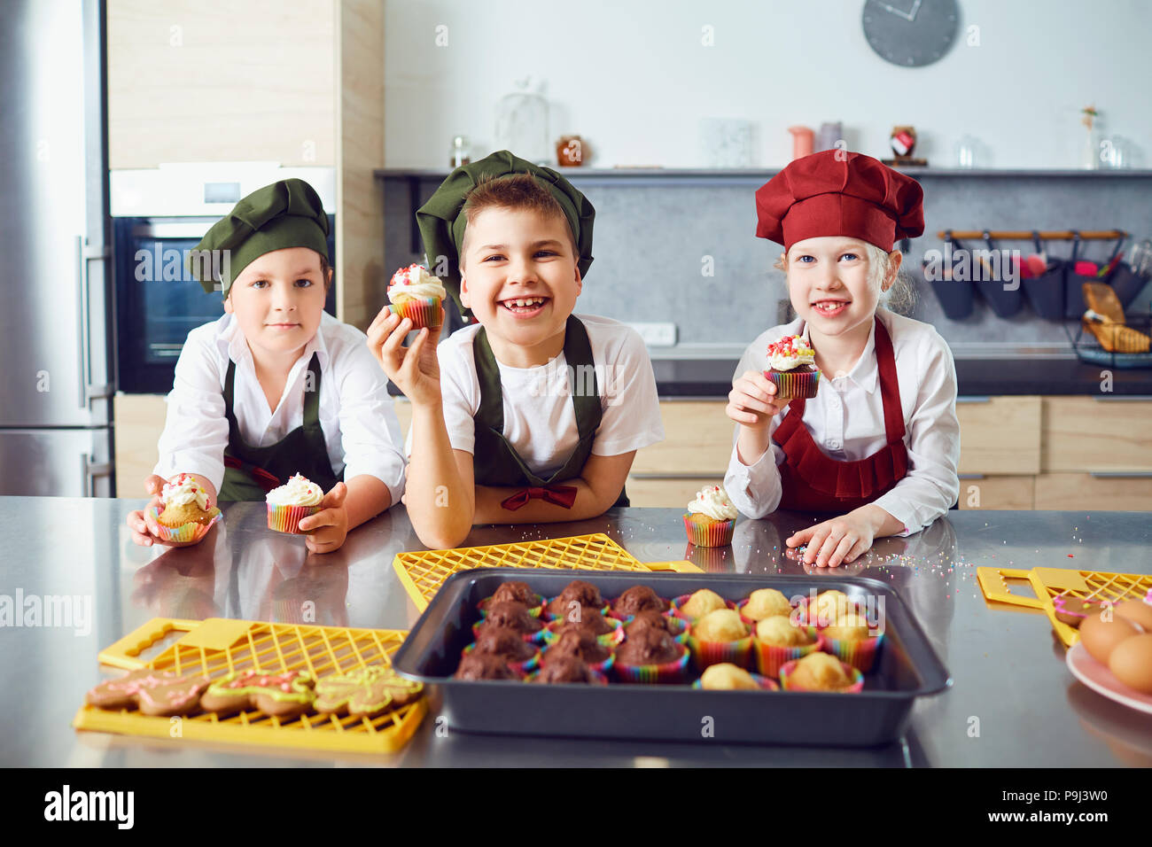 A group of children are cooking  in the kitchen. Stock Photo