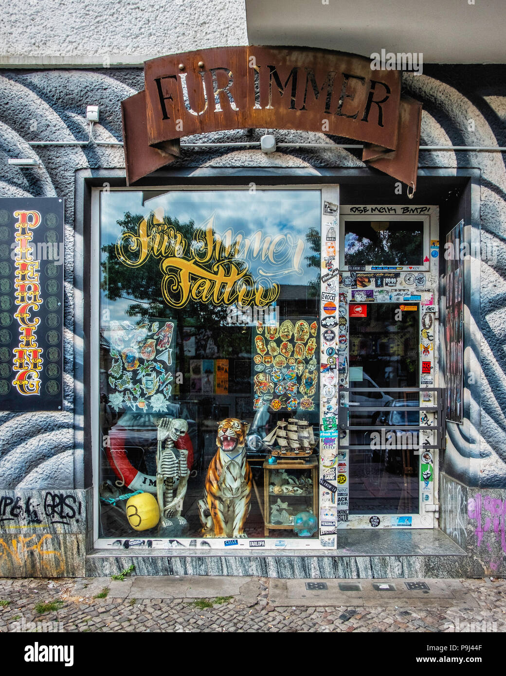 Berlin, Friedrichshain, Revaler str. 11. Fur Immer Tattoo shop exterior & entrance. Colourful display window Stock Photo