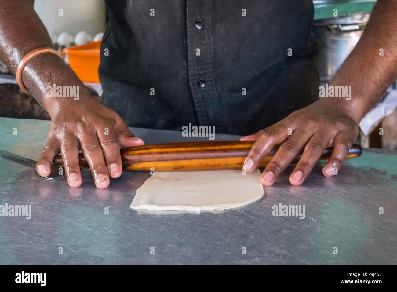 Cooking dough for baking in the kitchen, ready-made pies for baking, chef's hands prepare dough for making pies, rolls dough with a rolling pin. India Stock Photo